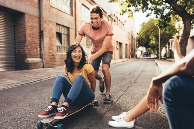 Friends having fun with skateboard on city street