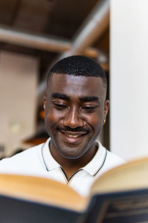 Black male reading book in cafeteria