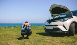 Young man desperate, car broken down