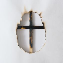 Canvas or paper burnt in egg shape with cross