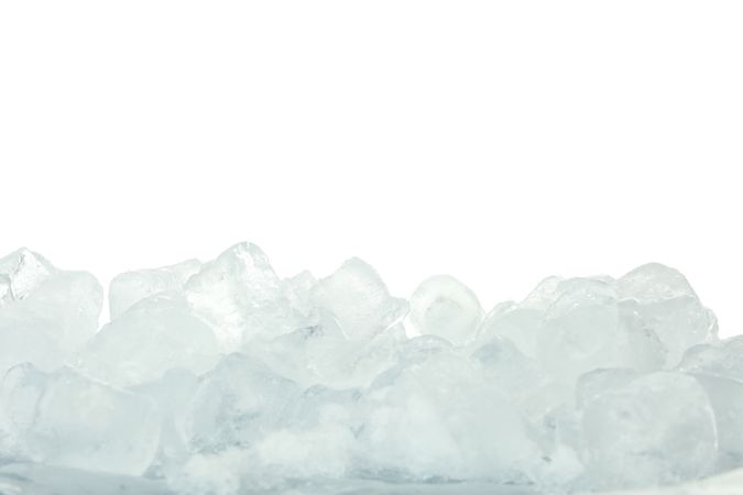 Ice cubes piled on plain background