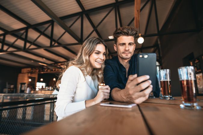 Attractive couple taking selfie while on date at brewery