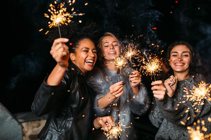 Multi-ethnic group of fun women at party with sparklers