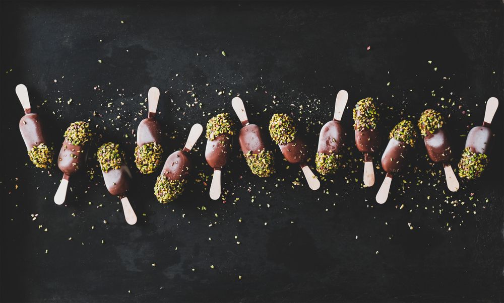 Ice cream chocolate pistachio popsicles, dark background, top view