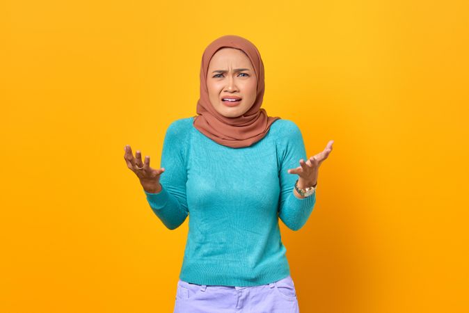 Muslim woman with arms up in exasperation