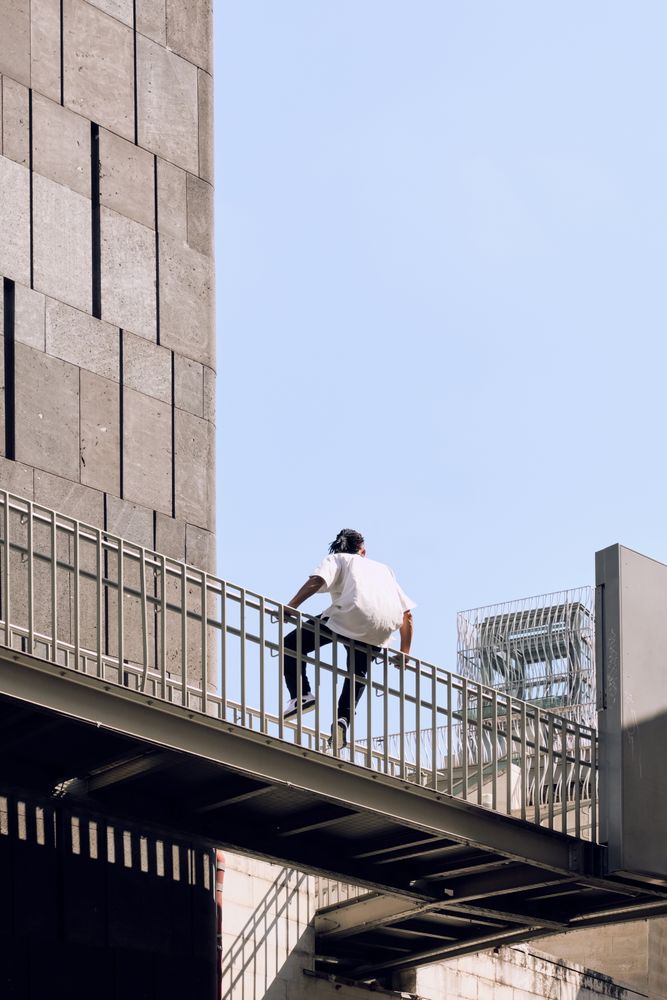 Black male sitting on bridge
