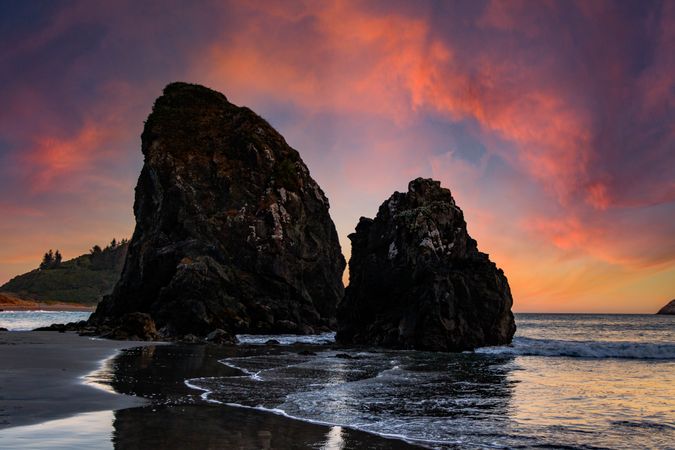 Two large rocks in the Pacific Ocean at dusk