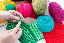 Person knitting green piece of clothing