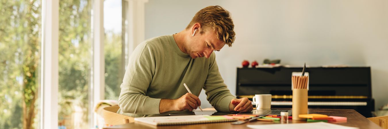Focused man using digital tablet to draw for work
