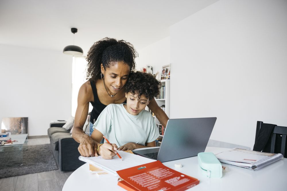 Girl doing her homework with mother