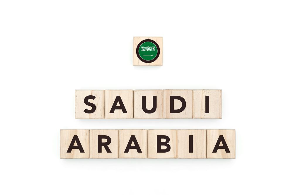 Wooden blocks bearing the name and flag of Saudi Arabia. Saudi and Arabian Culture, national identity, travel, and geography in a copy space design.