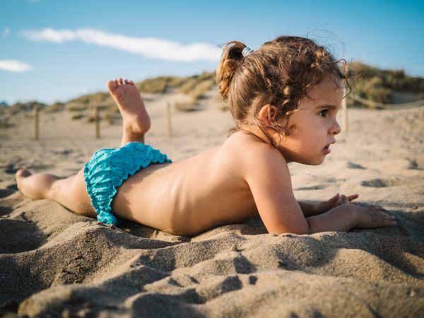 Girl playing on beach in sunny day