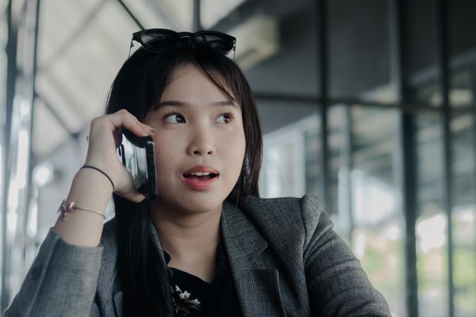 Surprised businesswoman receiving unexpected news via mobile pho