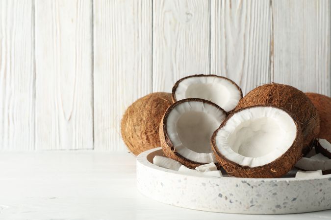 Tray with coconut on wooden background. Tropical fruit