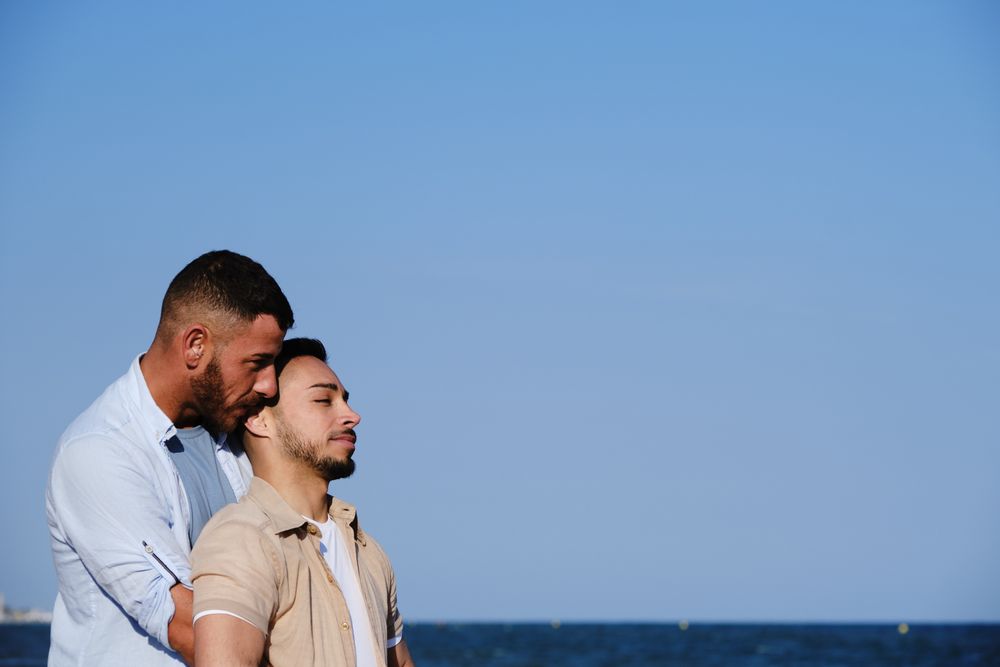 Male couple hugging on seaside