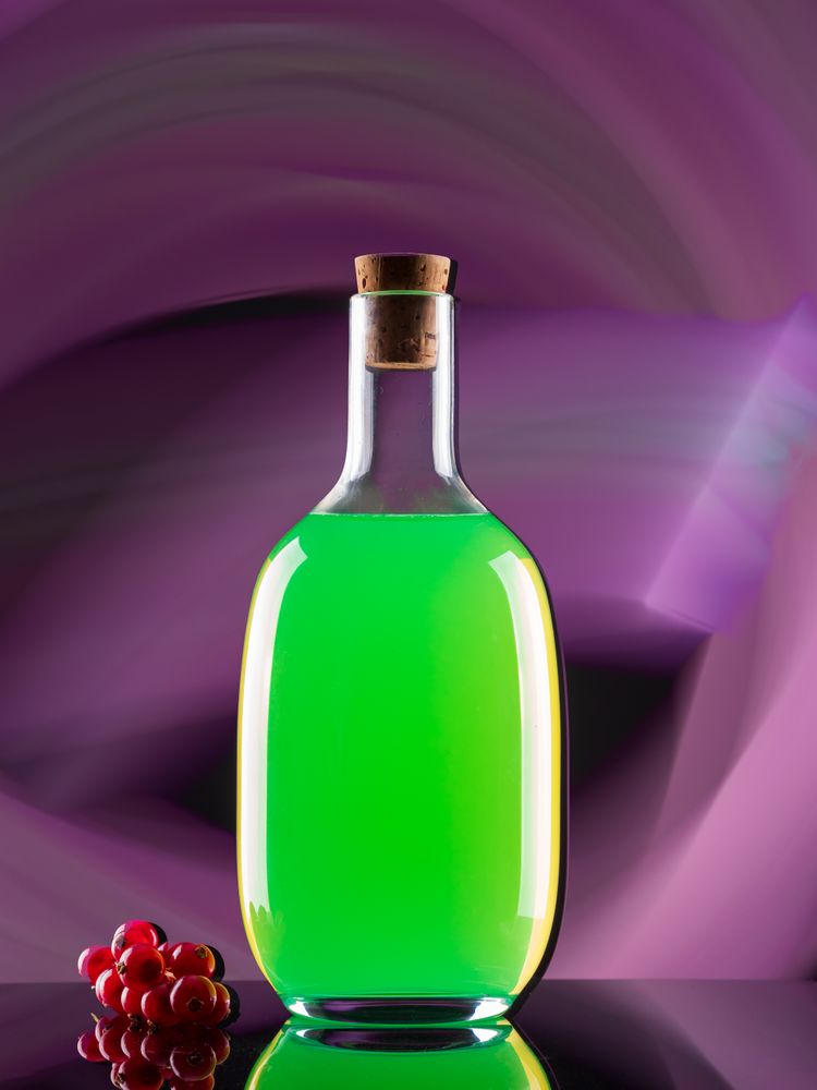 Bottle with drink near berries