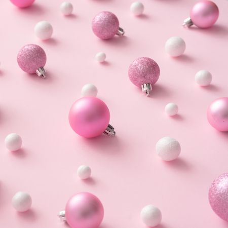 Different shades of pink and light-colored baubles on a pink background