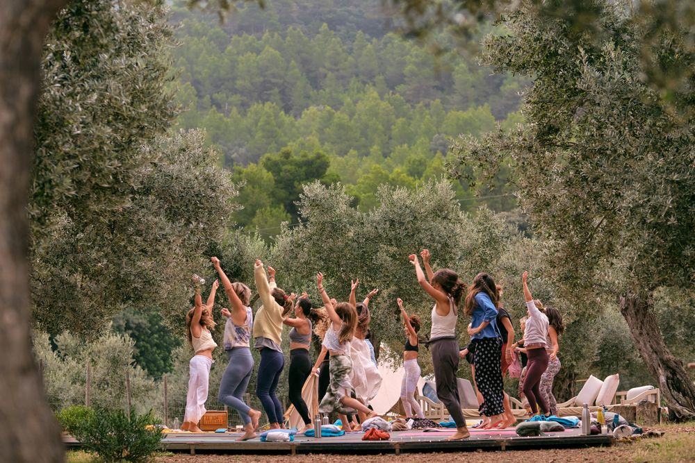 Group of women dancing with raised hands during aerobic class