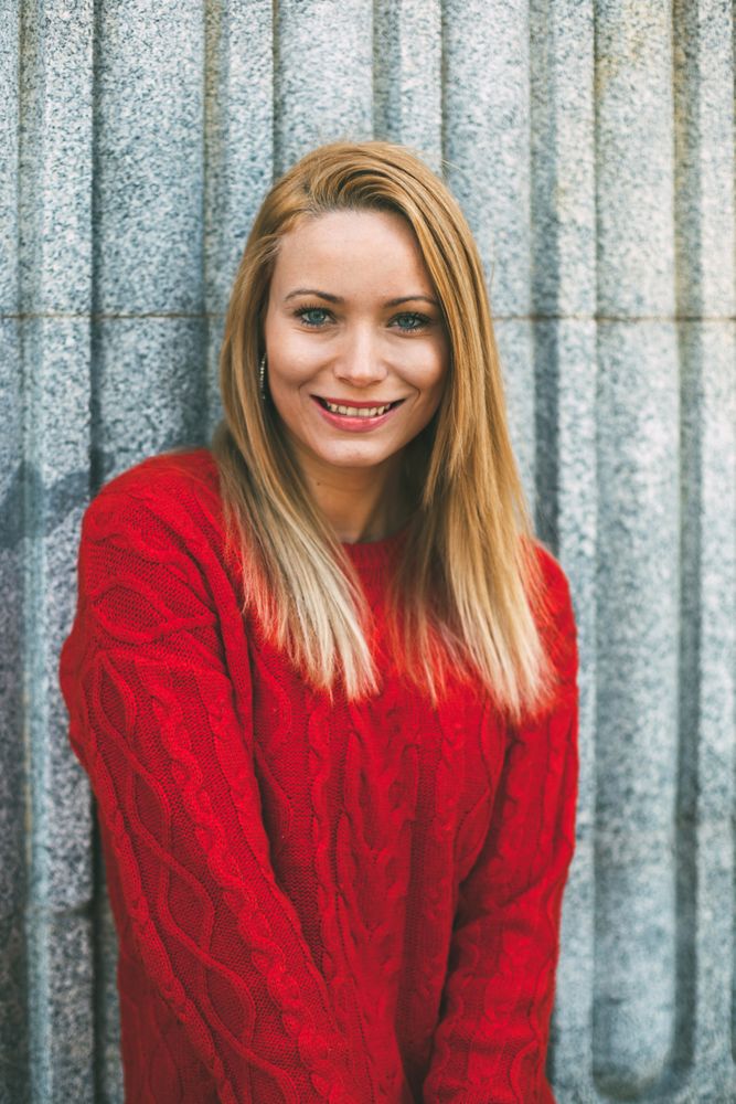 Stylish female standing near marble wall