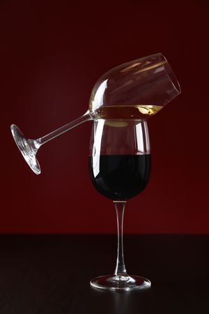 Glasses with wine against red background, copy space
