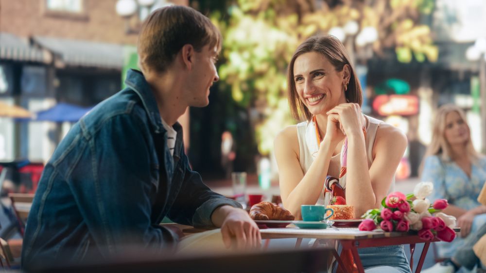 Happy Man and Woman Sitting on a Terrace and Having Fun Conversations During Their Breakfast Together in City Center on Weekend