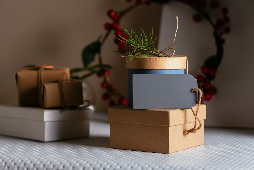 stacked Gifts boxs, wrapped in recycled paper and empty tag on table