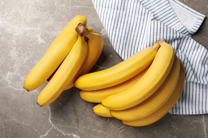 Towel and bananas on gray background. Fresh fruit