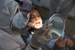Dentist analyzing teeth of boy during dental treatment