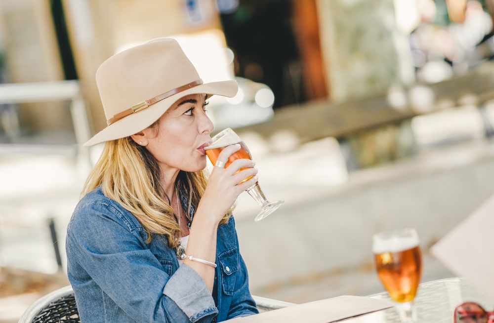 woman drinking sitting in outside cafe