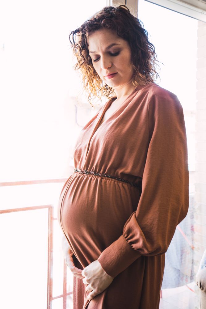 pregnant woman near balcony in room