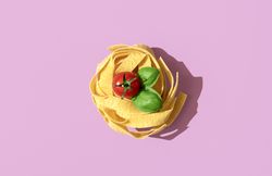Pasta nest uncooked, top view on a pink background