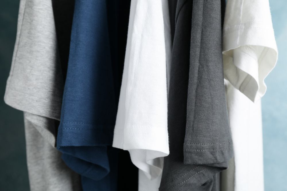 T-shirts on blue background, close up and space for text