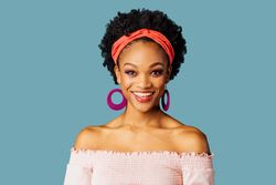 Studio shoot of joyful Black woman smiling at the camera in a blue space
