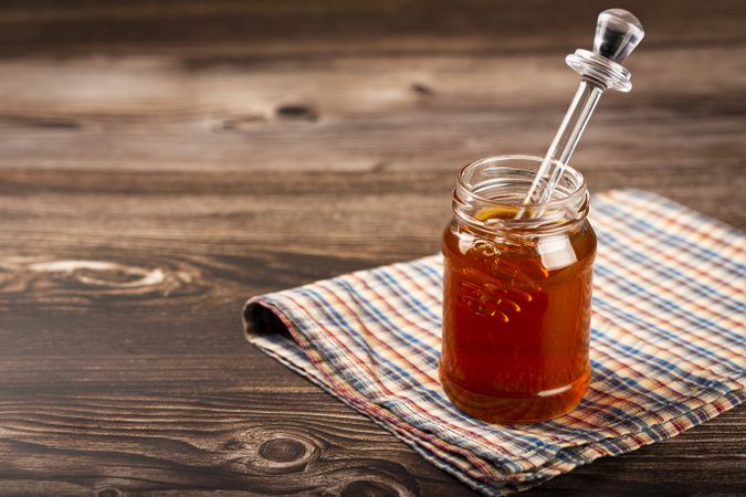 Honey in glass jar on the table.