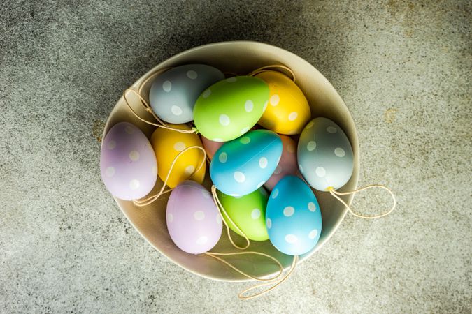 Easter eggs in bowl on concrete background