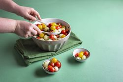 Melon caprese salad being mixed