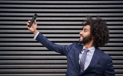 Joyful man taking selfie and smiling