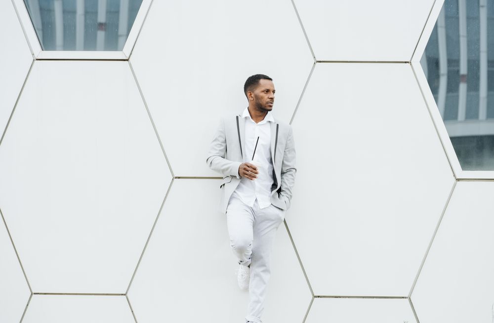 Black man with coffee standing in downtown