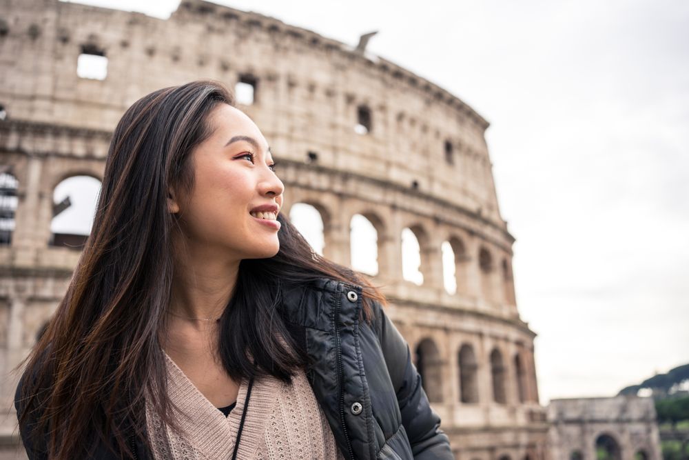 Cheerful Asian traveler outside famous landmark