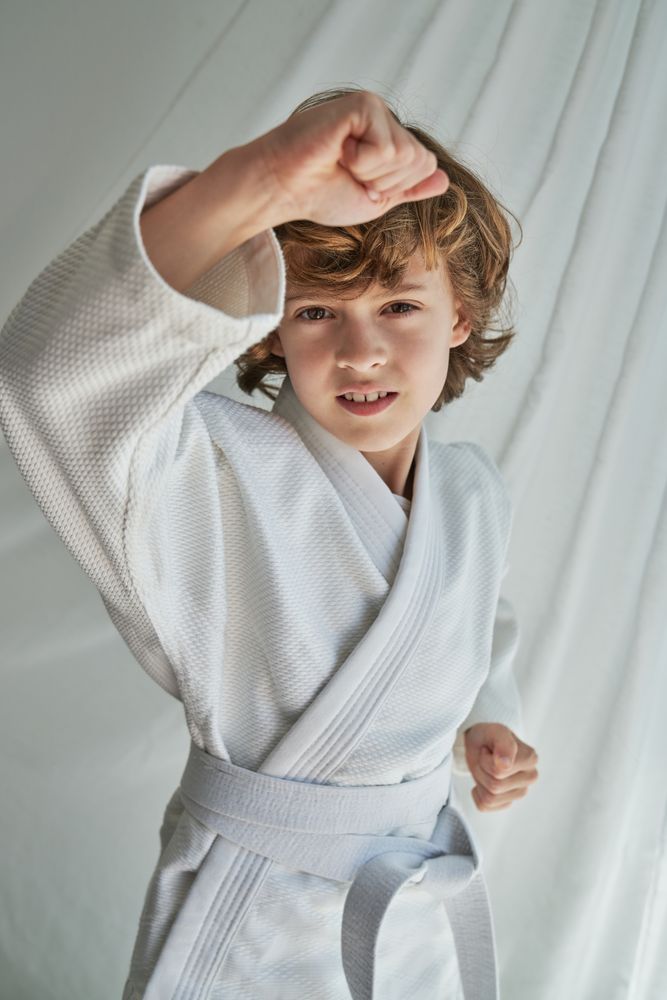 Serious boy in kimono doing karate