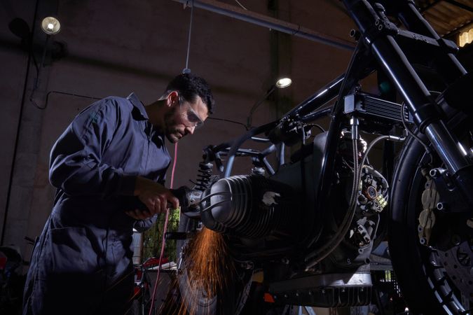 Man repairing motorbike in garage