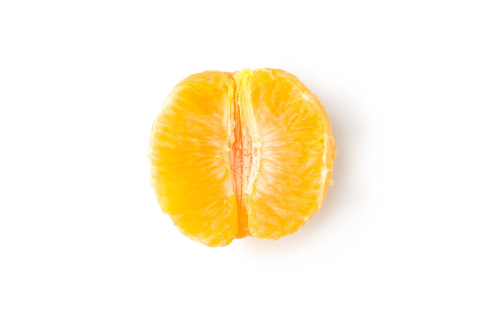 Half of ripe mandarin isolated on light background