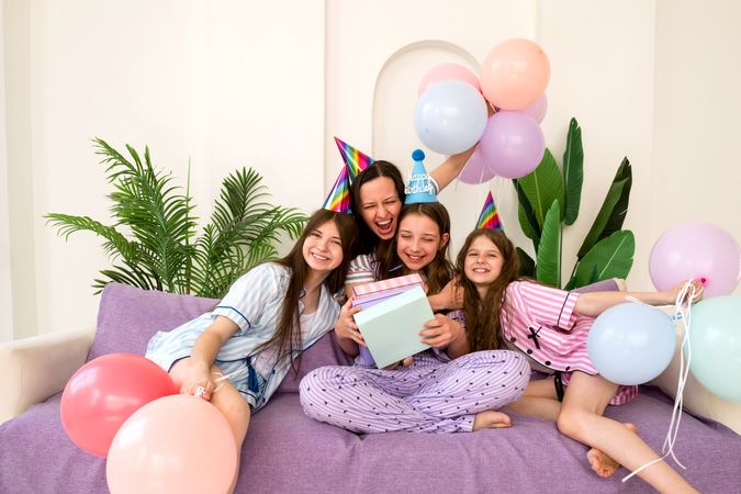 Family laughing and hugging during joyful birthday party at home.