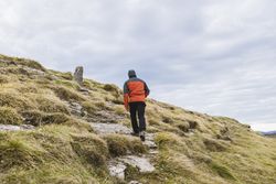 Man walking on hill near valley
