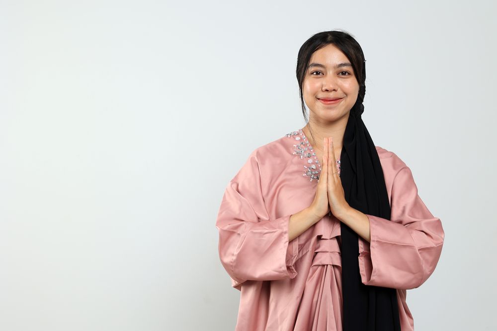 Young Asian Female Posing Hand Greeting for Eid Mubarak Celebration Concept.