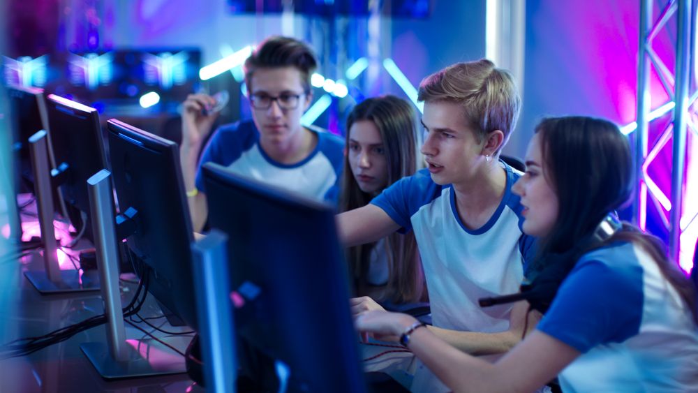Team of Professional  Gamers Actively Thinking/ Discussing Game Strategy/ Tactic, They're In Internet Cafe or on Cyber Games Tournament.