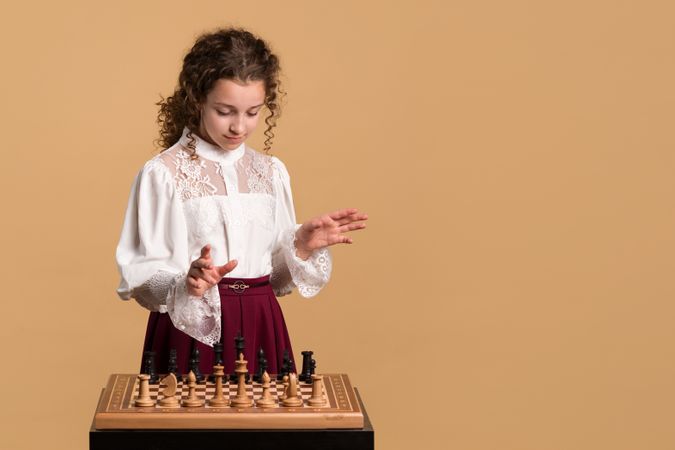 Young girl looking at chessboard in concentration