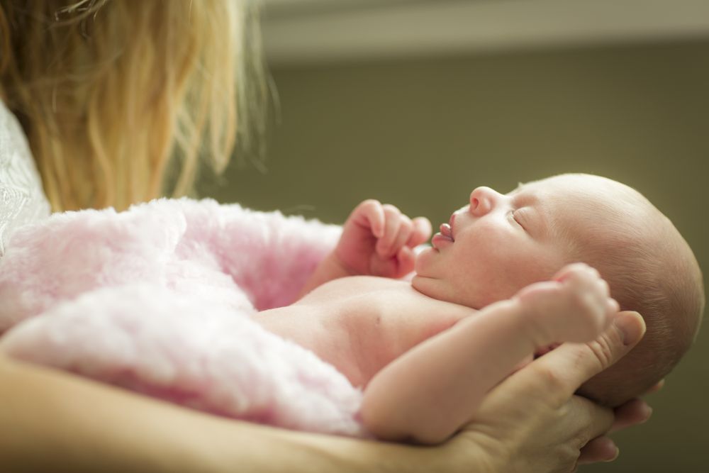 Hands of Mother Holding Her Newborn Baby Girl
