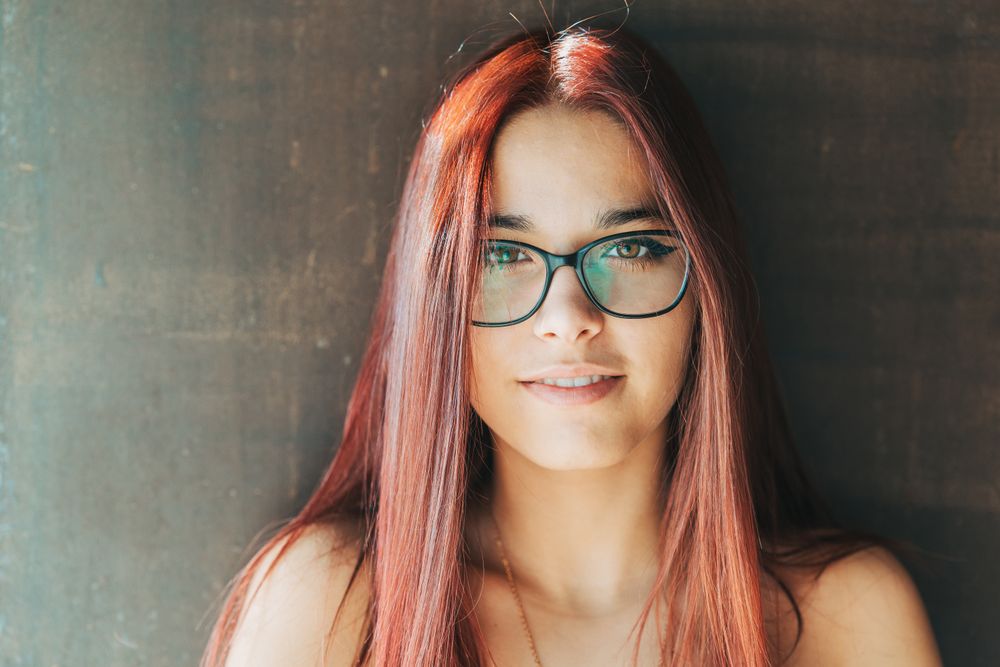 Woman in glasses leaning on wall
