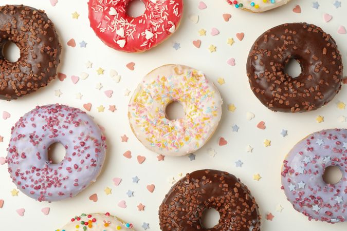 Flat lay with tasty donuts on plain background